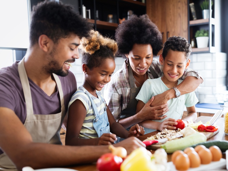 A family preparing a meal around the kitchen island.